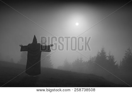 Fairy Wizard In A Cassock Standing On A Hill And Welcome Raising Sun Above The Foggy Valley. Black A