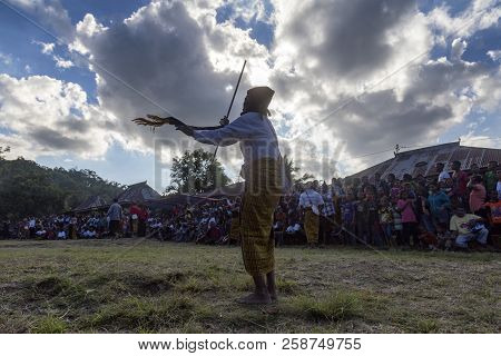 Bajawa, Indonesia - May 19: An Unidentified Man Performs Traditional Dance With A Pole And Scarf Nea