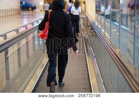 Woman At Horizontal Escalator Covered. Moving Walkway, Moving Sidewalk, Moving Pavement, Autopedesca