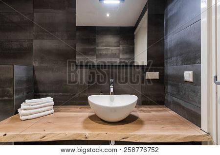 Modern Interior Of The Bathroom. The Washbasin Is Made Of White Massive Shell On The Table Of Wood. 