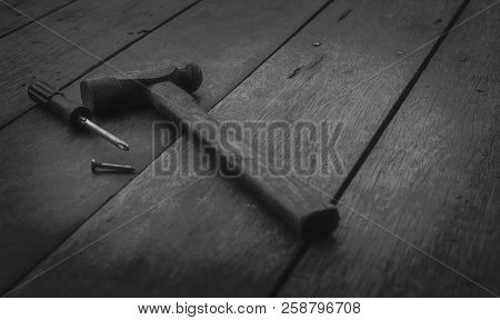Old Rusted Hammer, Screwdriver And Nail On Old Wooden Table. Woodwork Tools For Fix And Repair Home.