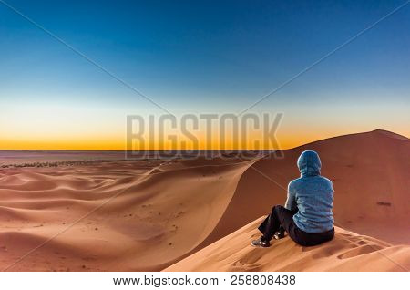 Woman Enjoing Sunrise In The Sahara Desert Next To M'hamid In Morocco