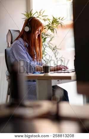 Female graphic designer working in office on modern computer