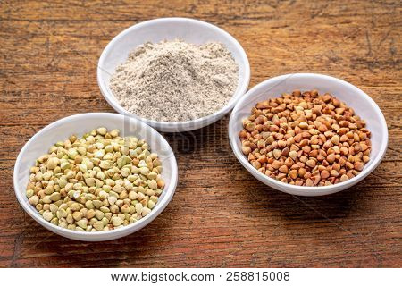 gluten free buckwheat groats, roasted kasha and flour - a set of small ceramic bowls against rustic wood