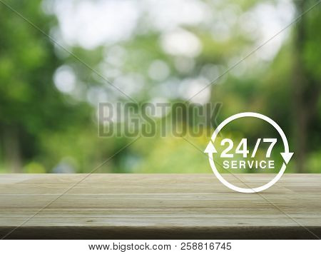 24/7 Service Flat Icon On Wooden Table Over Blur Green Tree Background, Full Time Service Concept