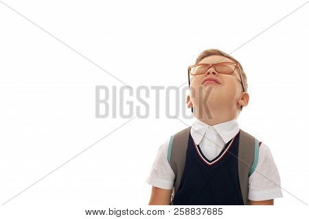 Funny Portrait Of Tired Little School Boy With Eyglasses And Backpack Standing On White Background.