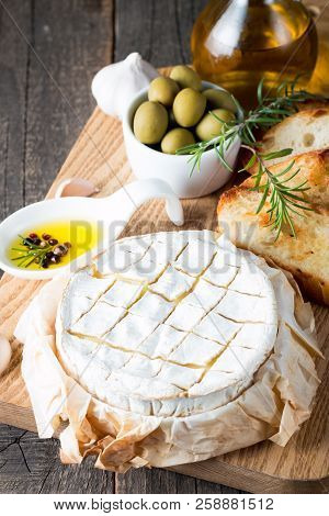 Baked Camembert Cheese. Fresh Brie Cheese And A Slice On A Wooden Board With Nuts, Honey, Rosemary, 