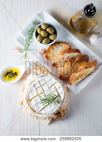 Baked Camembert Cheese. Fresh Brie Cheese And A Slice On A Wooden Board With Nuts, Honey, Rosemary, 