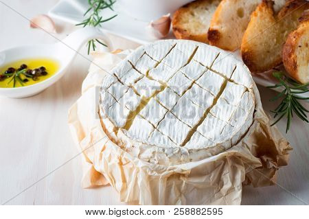 Baked Camembert Cheese. Fresh Brie Cheese And A Slice On A Wooden Board With Nuts, Honey, Rosemary, 