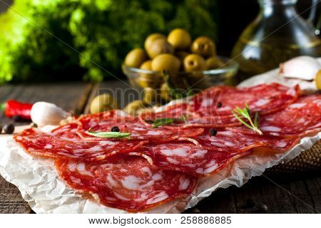 Chorizo Sausage And Salami, Thin Cut. Spanish Salami On The Wood Background With Spices, Paprika, Pe