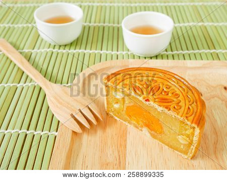 Durian Mooncake Cut In Half With Salted Egg Yolk On A Wooden Plate For Mid-autumn Festival Or Moonca