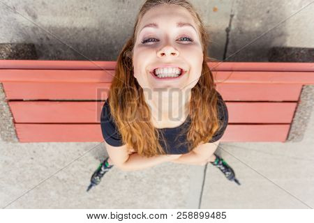 Close Up Of Funny Young Teenage Woman Wearing Rolling Skates. Bizzare Unusual Angle. Outdoor Shot.
