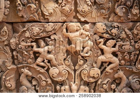 Stone Carved Bas-relief Of Banteay Srei Temple In Angkor Wat, Cambodia. Human Figures And Floral Orn