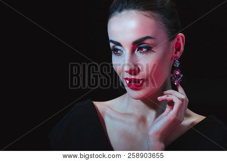 Sexy Vampire Woman Showing Her Fands And Looking Away Isolated On Black
