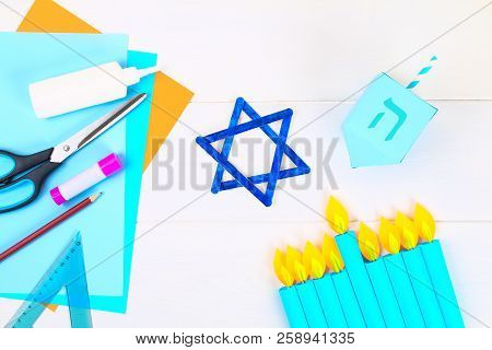 Menorah, Dreidel, Sevivon, The Star Of David With Their Own Hands On A White Wooden Table. Diy For A