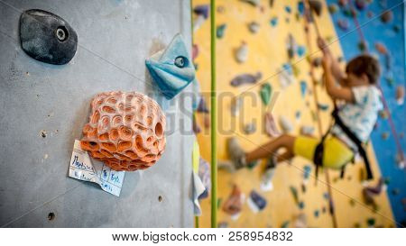Young Boy Is Climbing On Artificial Climbing Wall