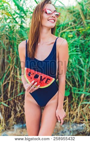 Beautiful Young Female In Swimsuit And Red Sunglassses Hold Slice Of Watermelon With Inscription Lov