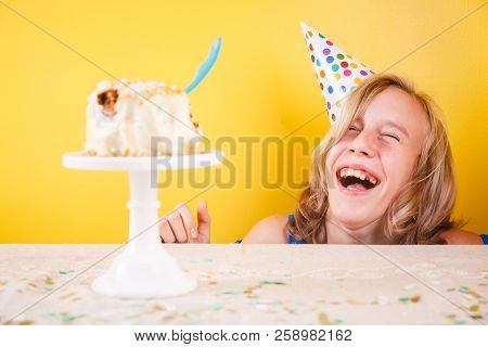 Teenage Girl Enjoying Herself After Ruining Birthday Cake. One Person Party. Concept Of Birthday Par