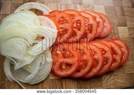 Red Tomato With Bow Slices On Chopping Board