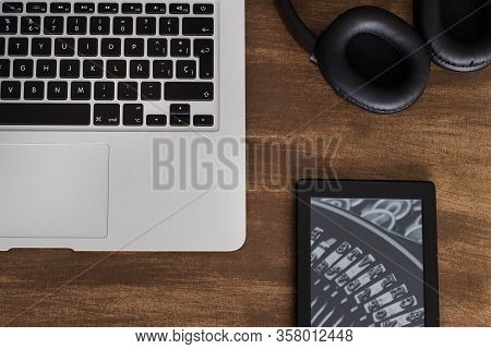 Laptop On The Table With Wireless Headsets And Ebook