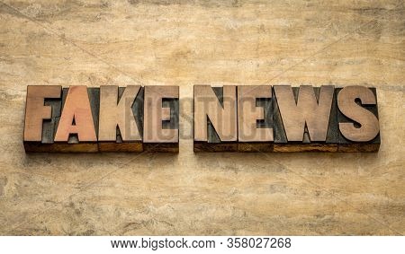 fake news word abstract in vintage letterpress wood type against grunge paper, social media and infodemic concept
