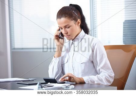 businesswoman with mobile phone in offece