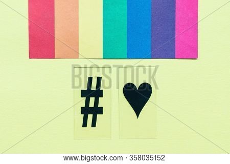 Rainbow Flag, Hashtag And Heart Symbols On Yellow Background. Lgbtqi Love Concept. Copy Space