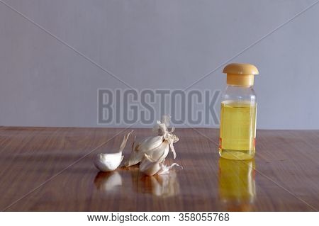 Garlic Food And Oil Bottle On Wooden Table. Nutritional Supplements Ingredients. Antioxidant Harbal 