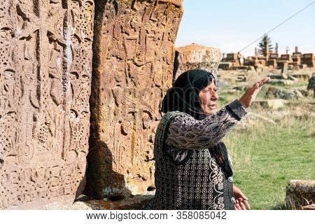 Noratus, Armenia-may, 01 2019: Unique Cemetery Of Khachkars, Old Armenian Woman Talk About Khachkars