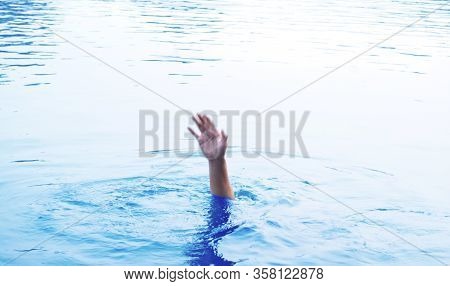 Blurred Image Hand Out Of Focus, People Raising Hands For Help Are Drowning  In Sea.drowning Person 