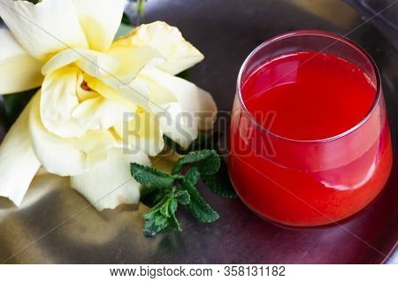 Red Orange Juice O Grapefruit Juice In A Glass On Steel Plate With Mint Leaf And Yellow Rose. Vitami