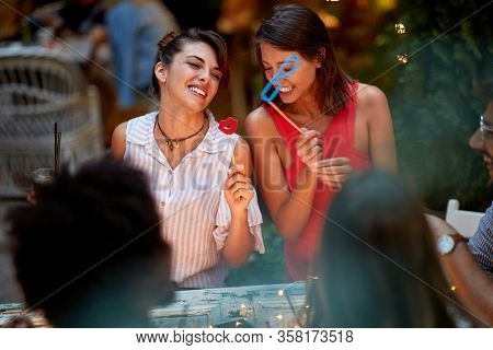 Girls on birtday party holding stick with sunglasses and lips