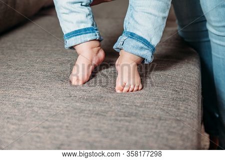 Baby's First Steps. The Baby's Feet Take The First Steps. Photo Of Children's Legs Barefoot.
