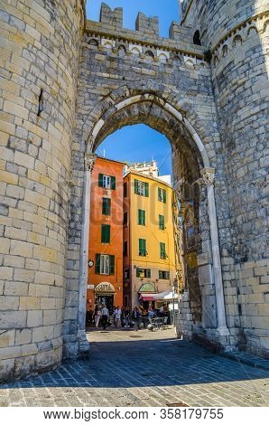 Genoa, Italy, September 11, 2018: Medieval Tower Porta Soprana Brick Gate And Colorful Buildings Wit