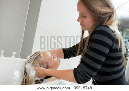 Kosmetička mytí vlasů zákaznici šamponem krása Spa