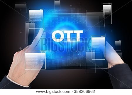 Close-up of a hand holding tablet with OTT abbreviation, modern technology concept
