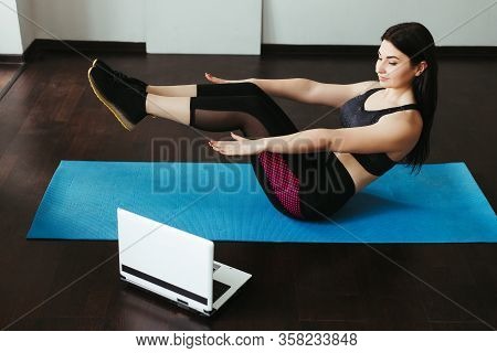Sport, Home Training, Online Fitness Class. Young Fit Woman Doing Sit-ups On Mat At Home Looking Vid