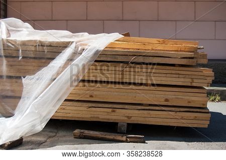 Load Of Boards Partially Covered With Plastic Wrap For Weather Protection.