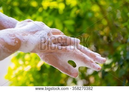 Women Washing Hands With Soap And Water On Green Blur Background.