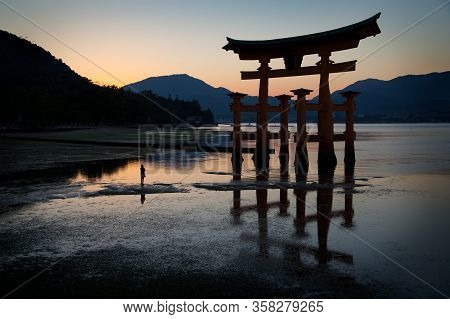 A Silhouette Of A Woman In Front Of The Torii Of Miyajima. Close To Hiroshima