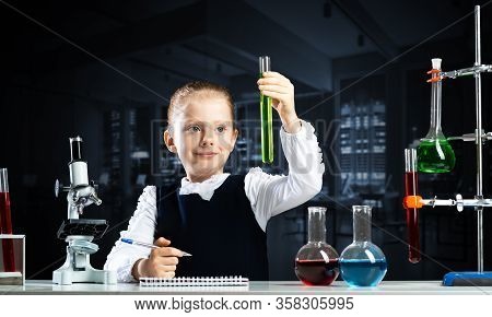 Little Girl Scientist Examining Test Tube With Chemical Reagent. Research And Education In School. C