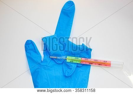 Medical Protective Glove And Thermometer. A Glove Is An Obscene Gesture. Covid-19