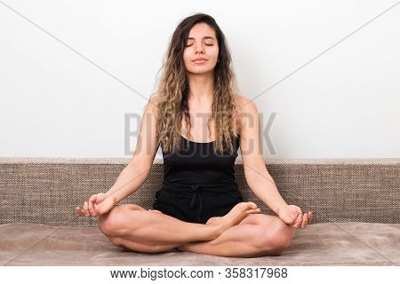 Releasing All Bad Energy From News. Young Woman With Curly Hairs In Lotus Pose Meditating And Doing 