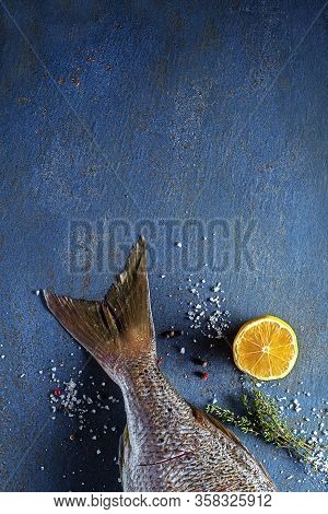 Delicious Fresh Fish Tail With Spices On Vintage Blue Background. Healthy Diet Eating Or Cooking Con