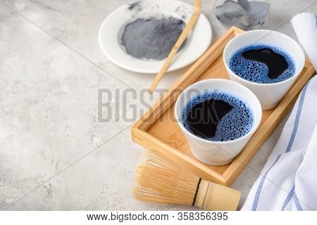 Blue Matcha Tea In Two White Cup , Wooden Tray, Bamboo Tavan And Tasaku, Powder On White Gray Backgr