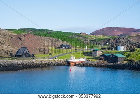 Old Buildings And Boat At The Coastline Of Island Of Heimaey