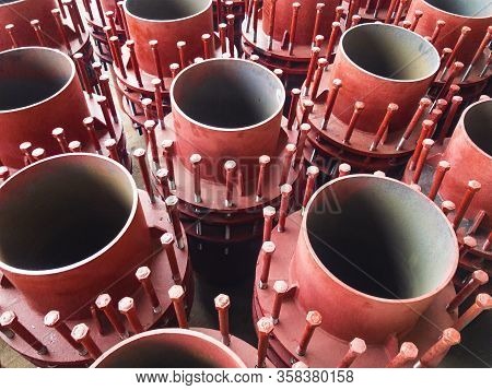 Red Gland Expansion Joints For Heating Main On Concrete Floor. Heat And Power Concept.