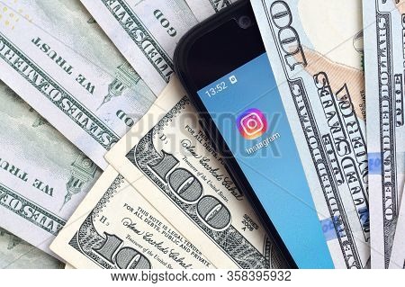 Smartphone Screen With Instagram App And Lot Of Hundred Dollar Bills. Business And Social Networking