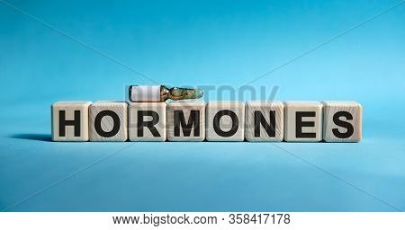 Hormones - Text On Cubes. Drug In Ambula To Reduce Disease Symptoms On A Blue Background