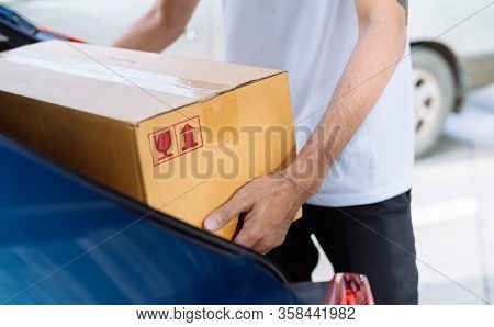 Close-up Delivery Man Carrying Cardboard Box For Sending To Receiver Customer By Transportation Syst